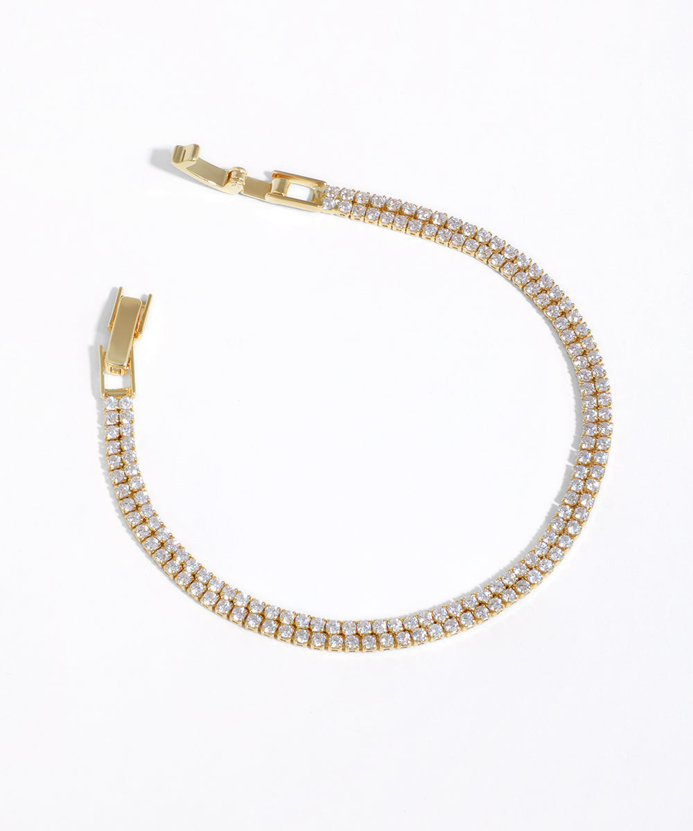 Gold-tone bracelet with two rows of clear cubic zirconia stones and a box clasp closure.