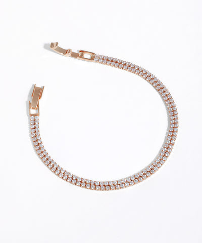 Rose gold bracelet with clear stones on a white background