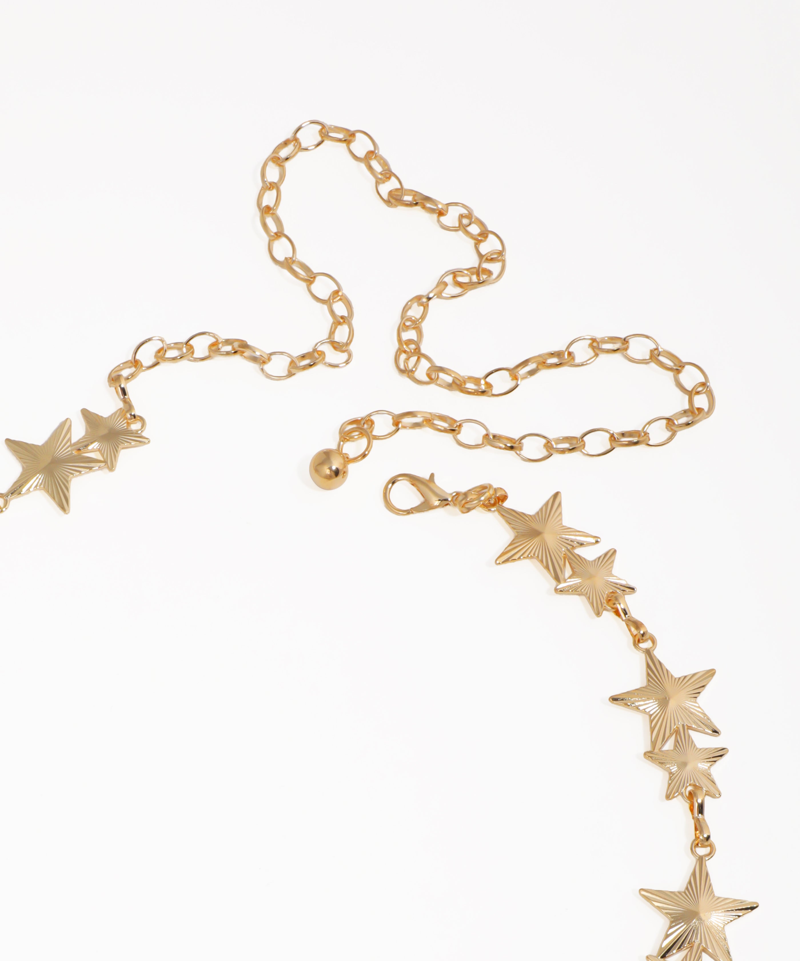 Gold necklace with star-shaped pendants on a white background