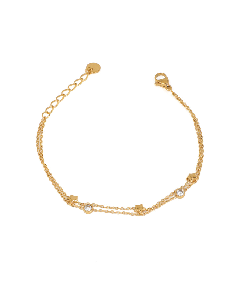 Gold-tone layered bracelet with small bezel-set CZ stones and tiny star charms, lobster clasp
