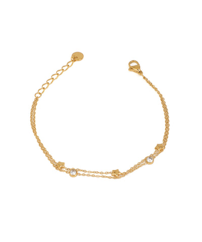 Gold-tone layered bracelet with small bezel-set CZ stones and tiny star charms, lobster clasp