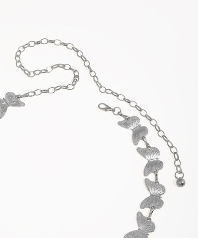 Gold butterfly necklace on a white background
