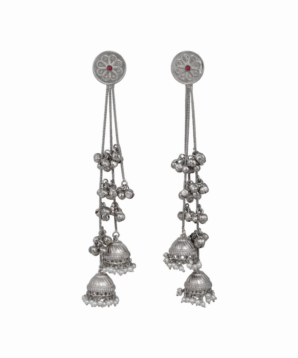 Pair of silver earrings with hanging components on a white background