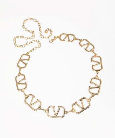 Gold-tone waist chain with bold, open geometric V-shaped links and an adjustable chain closure.