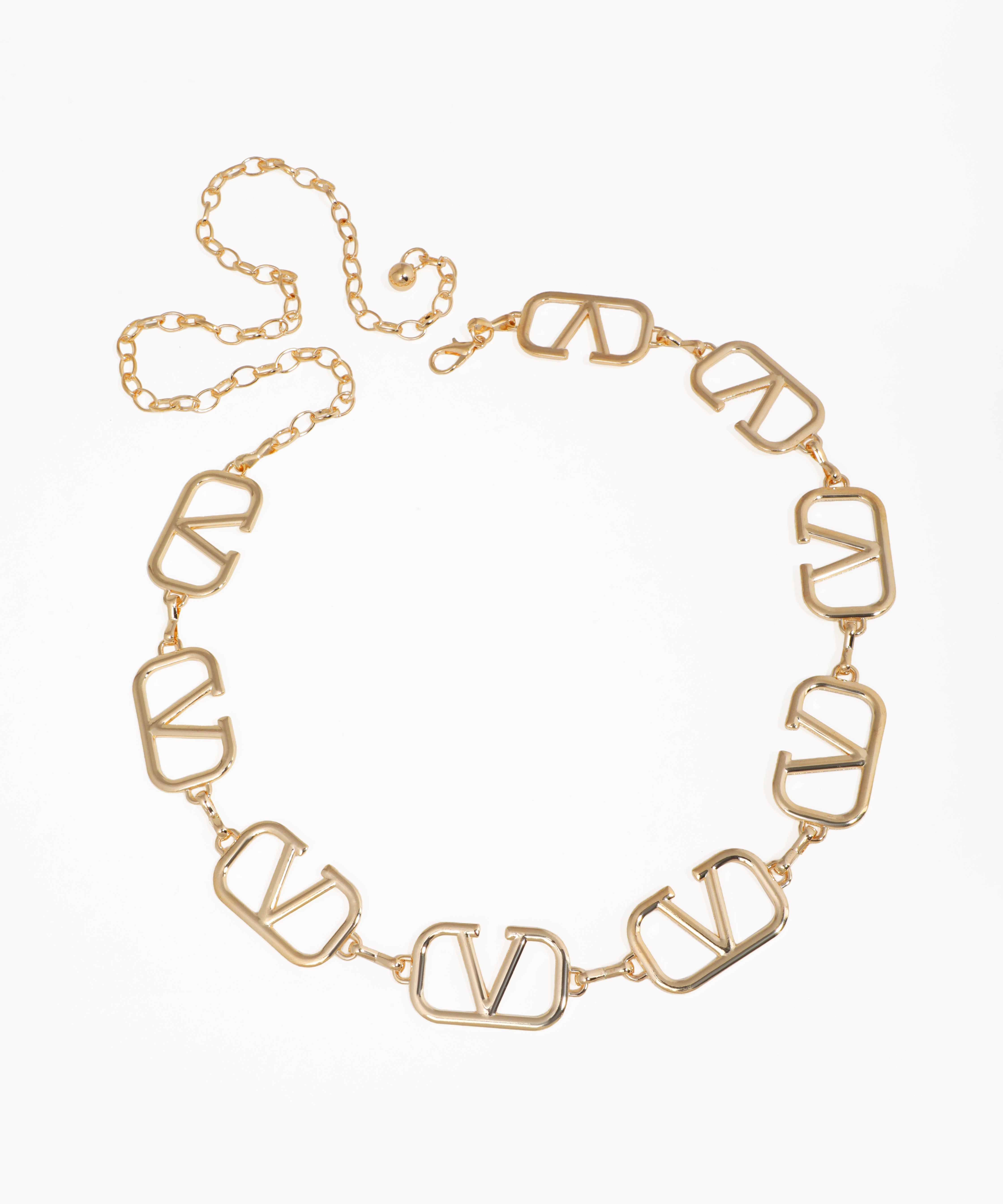 Gold-tone waist chain with bold, open geometric V-shaped links and an adjustable chain closure.