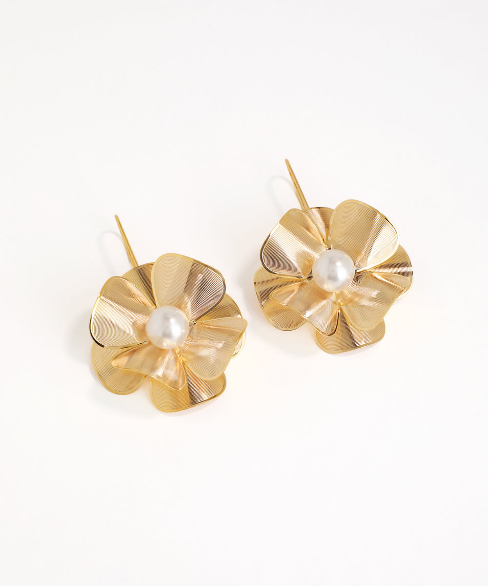 Gold flower-shaped earrings with pearl centers on a white background