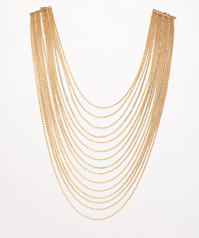 Gold-tone and rhodium finish multi-strand necklace with cascading chains and delicate clear stones.