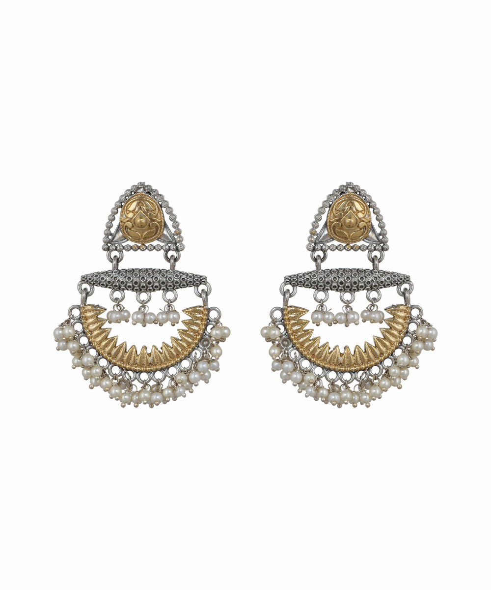 Pair of ornate earrings with gold and silver design on a white background