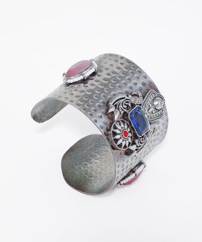 Oxidise cuff bracelet with hammered texture and intricate settings of pink, blue, and red stones with white accents.