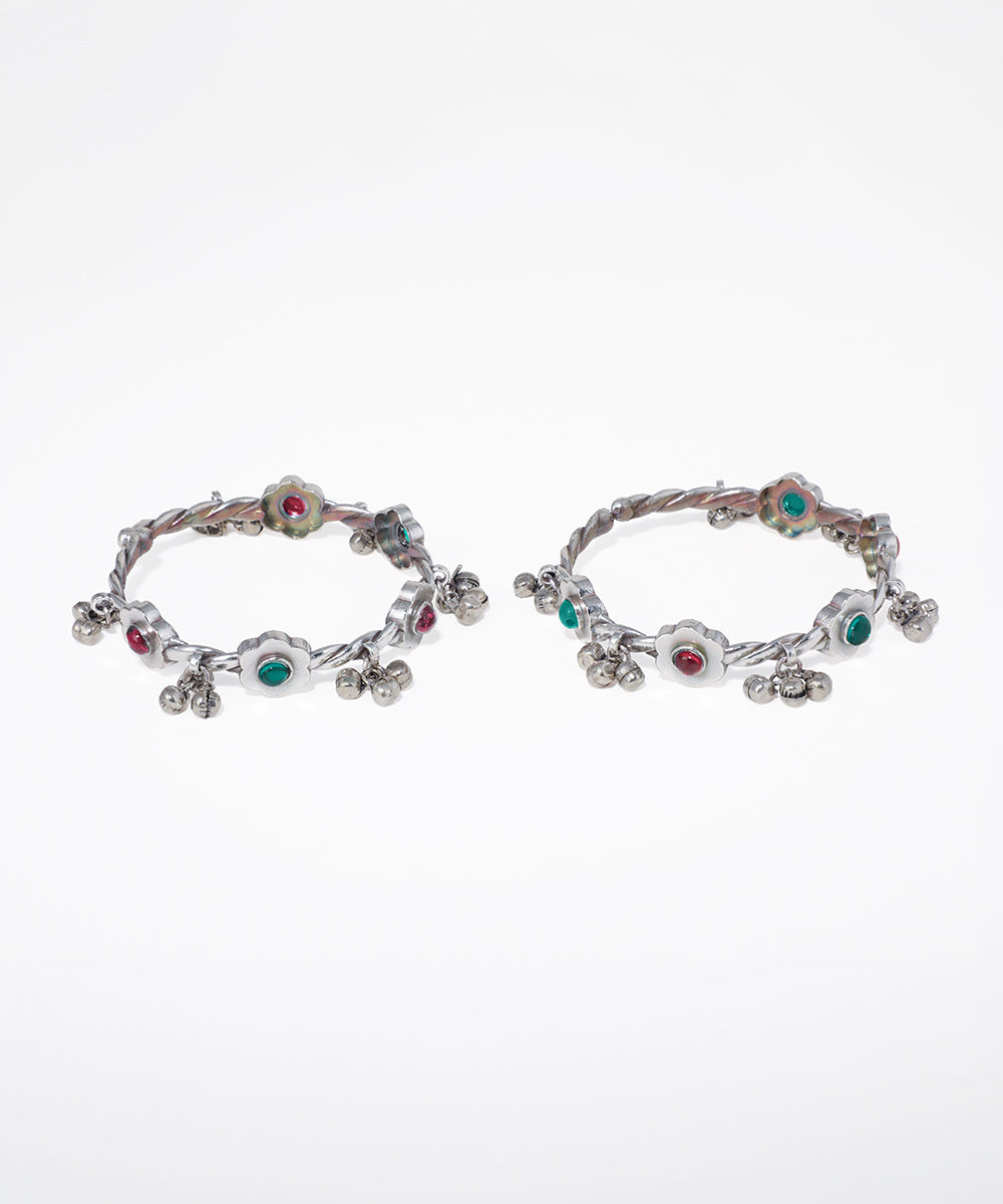 Pair of hoop earrings with colorful gemstones on a white background