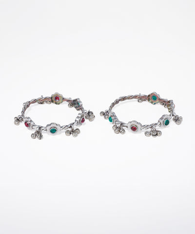 Pair of hoop earrings with colorful gemstones on a white background
