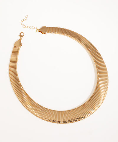 Gold-tone necklace with a wide, ribbed collar design and an adjustable extender chain