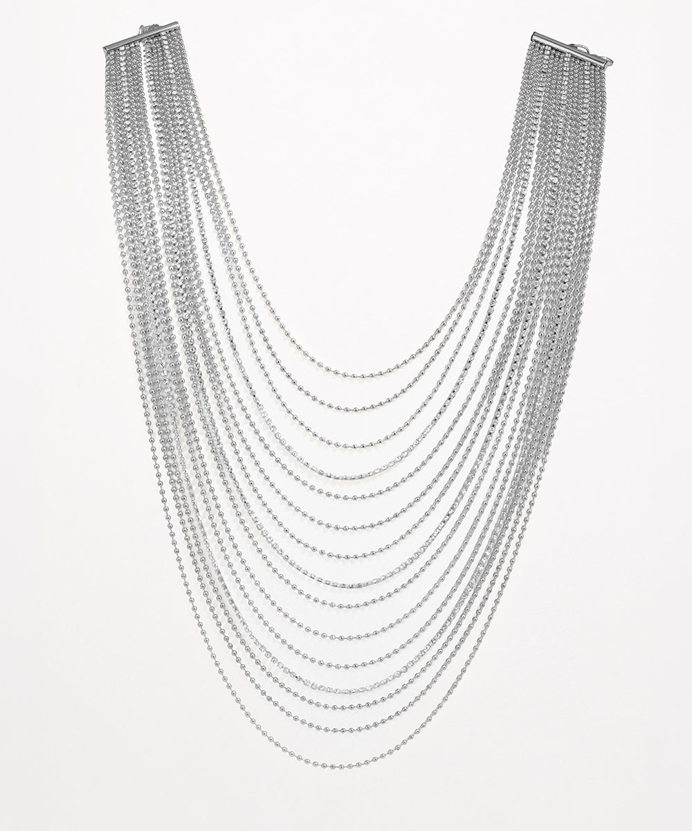 Multiple strands of silver chain necklace on a white background