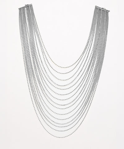 Multiple strands of silver chain necklace on a white background