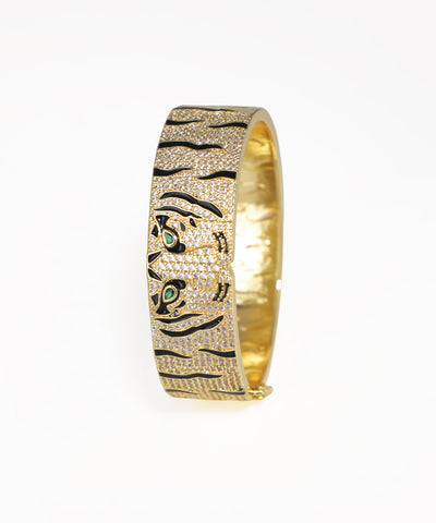 Gold bracelet with tiger design on a white background
