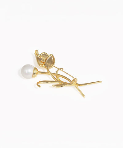 Gold rose-shaped earring with pearl on a white background