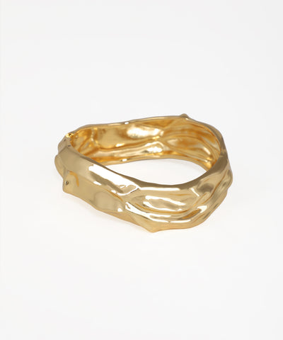 Gold ring with a textured design on a white background