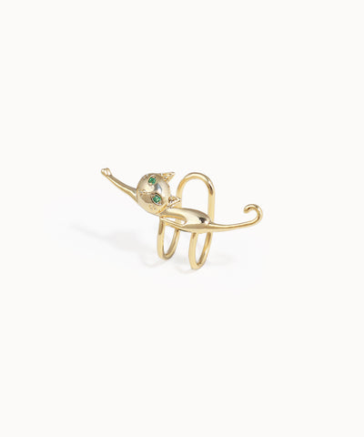 Gold elephant-shaped ring with green gemstones on a white background