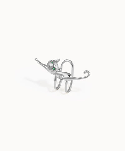 Silver ring shaped like a cat with green eyes on a white background