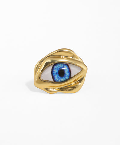 Gold-tone ring with a wavy, sculptural band featuring a realistic blue eye motif