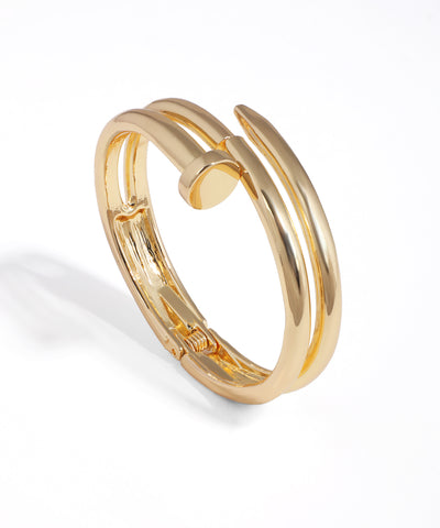 Gold-tone bangle bracelet with a distinctive nail-inspired design and hinged clasp closure.