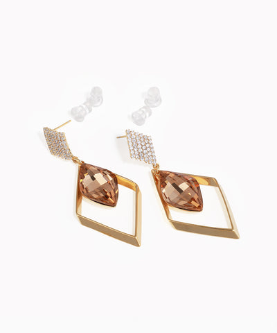 Gold-tone drop earrings with studded top and faceted brown stone in geometric frame.
