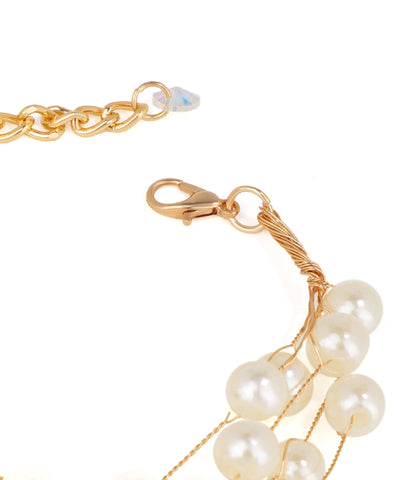 Gold bracelet with pearl-like beads on a white background