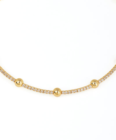 Gold necklace with small beads on a white background
