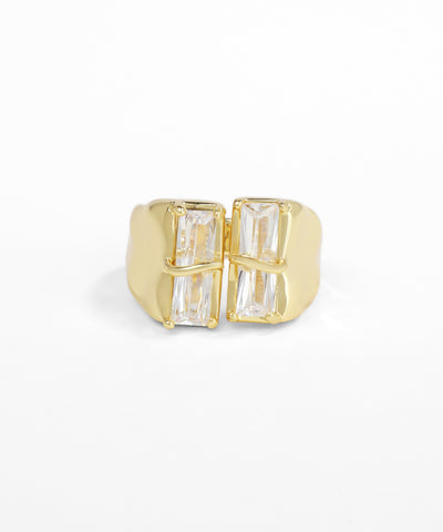 Gold ring with baguette cut gemstones on a white background
