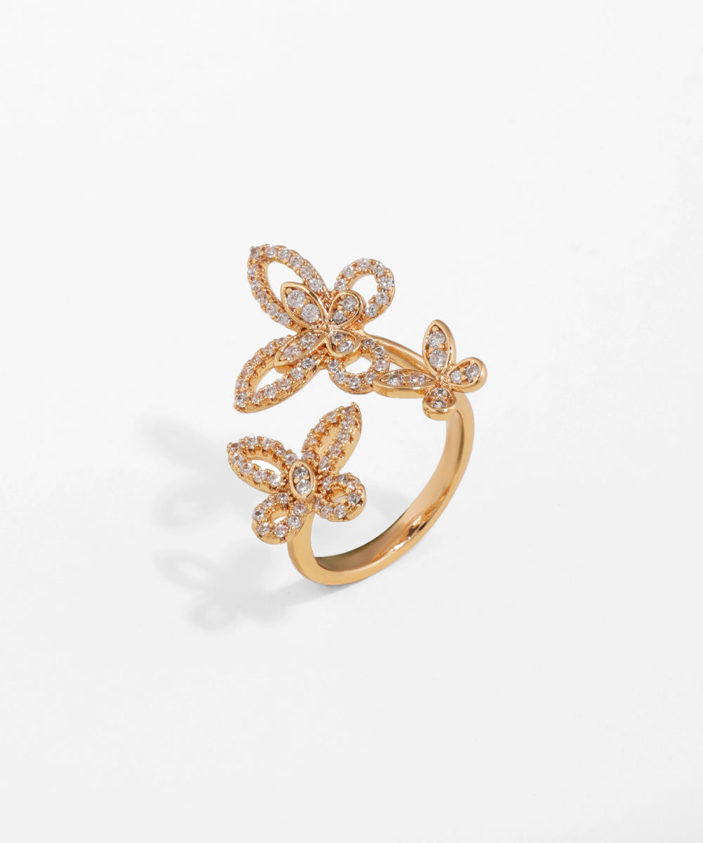 Gold-tone open ring with two sparkling butterfly motifs adorned with clear stones.