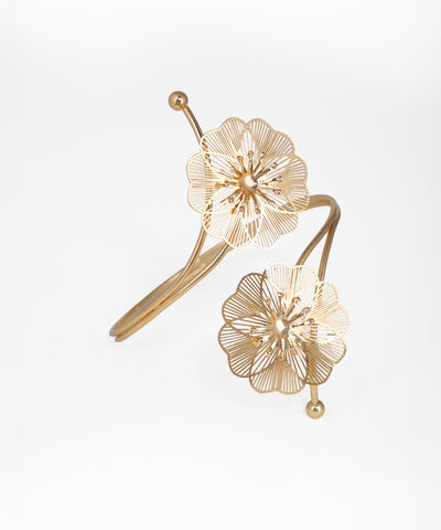 Gold floral earrings on a light gray background
