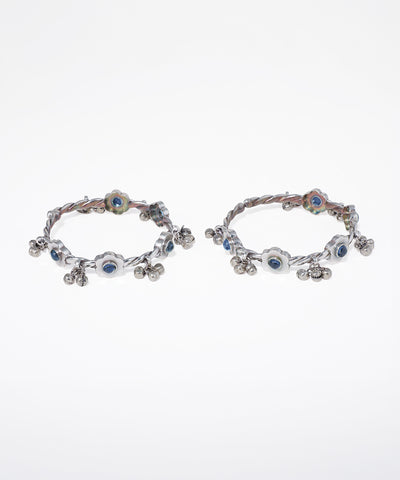 Pair of hoop earrings with blue gemstones on a white background