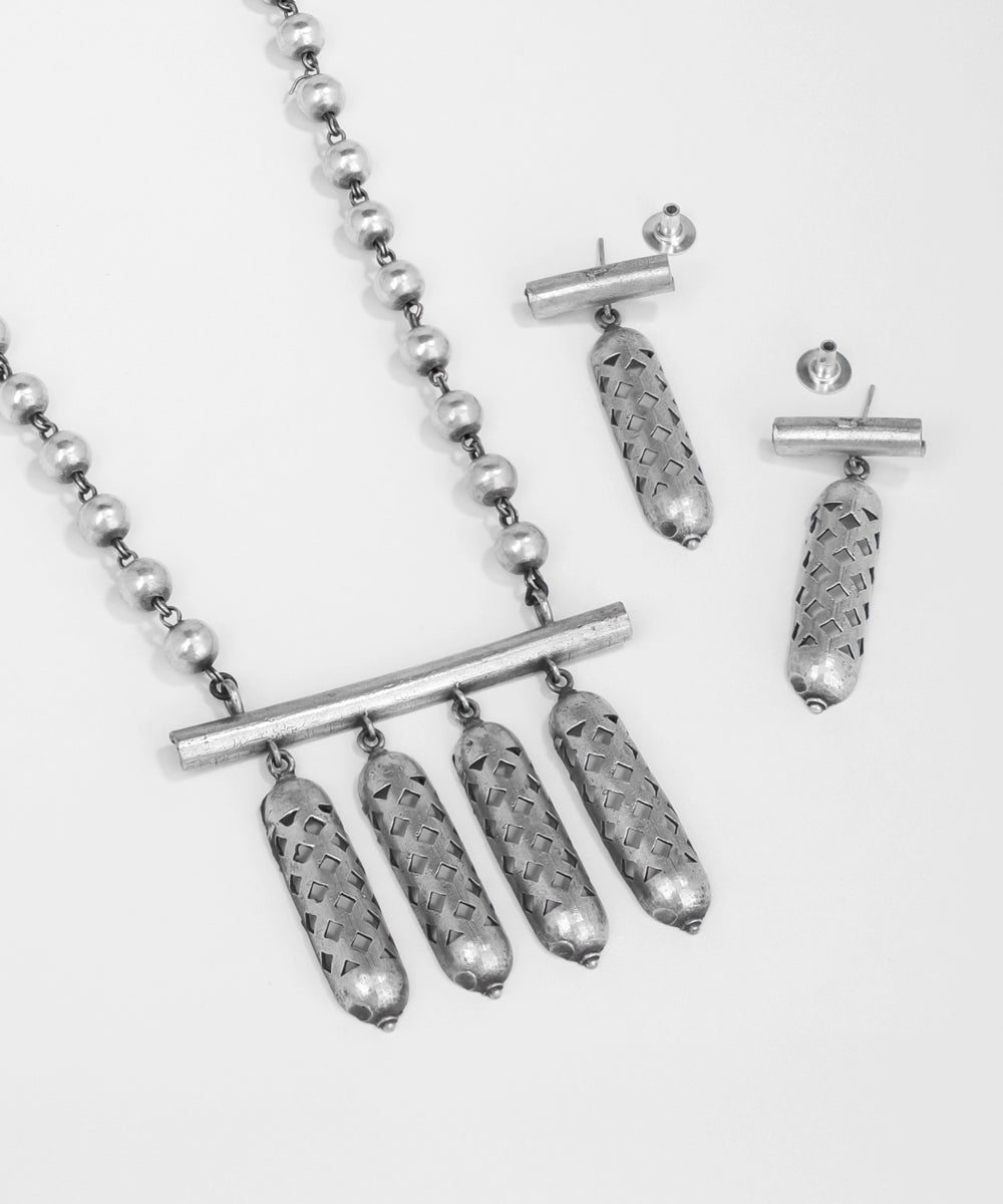 Silver necklace and earrings on a white background