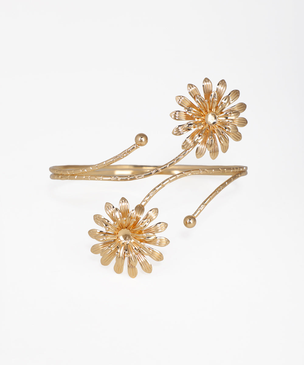 Gold floral cuff bracelet on a white background