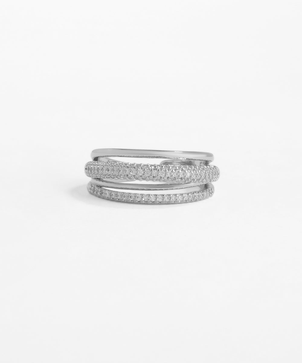 Set of three silver rings stacked on a light gray background