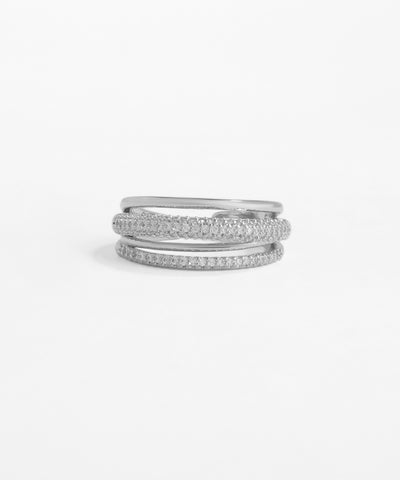 Set of three silver rings stacked on a light gray background