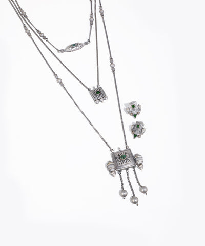 Silver necklace with green gemstones on a white background