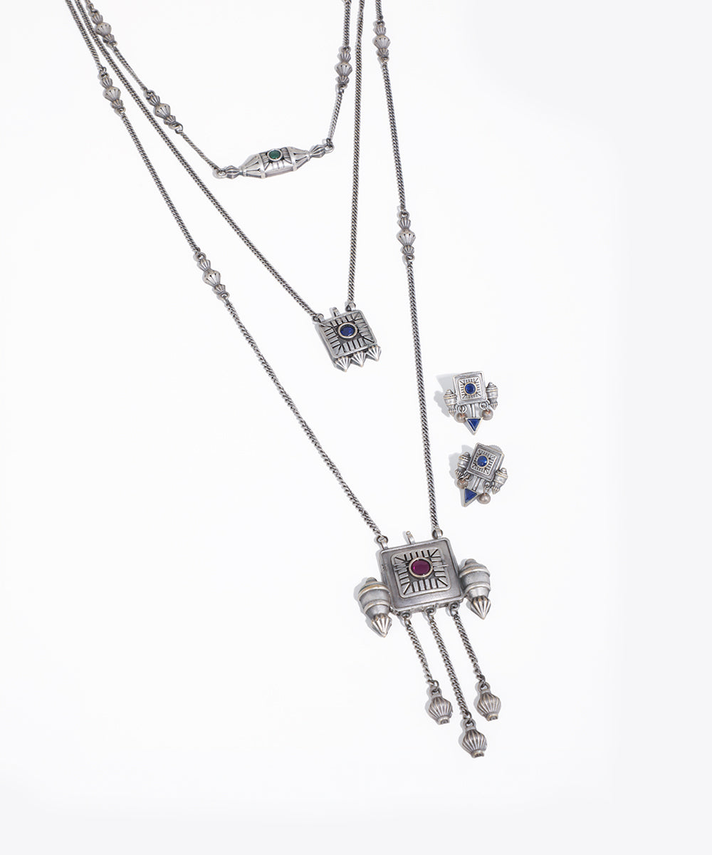 Silver necklace with pendant and matching earrings on a white background