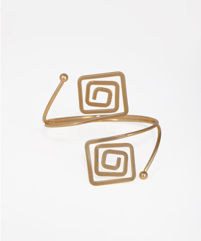 Gold spiral bracelet on a light beige background