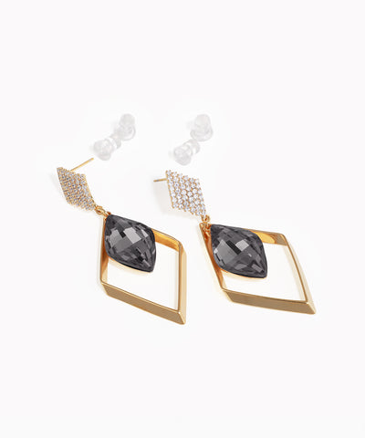 Gold and black earrings on a white background