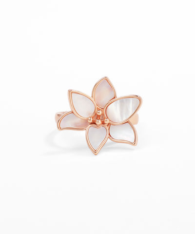 Rose gold ring with a white floral design on a white background