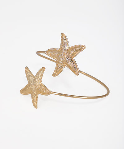 Gold-tone arm cuff with two textured starfish designs on an open band