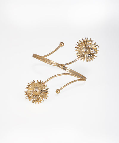 Gold bracelet with floral designs on a white background
