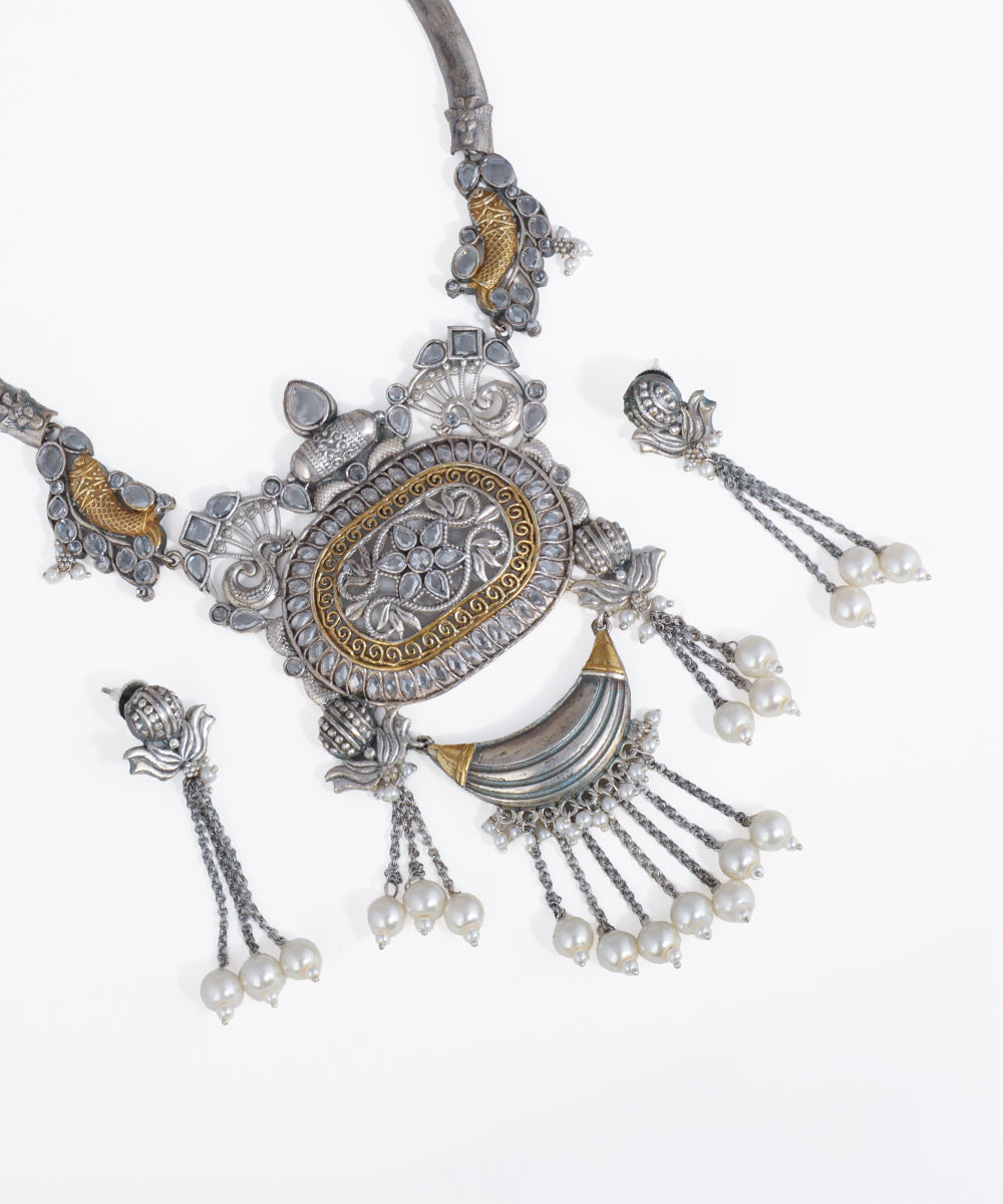 Ornate silver and gold necklace with pearl accents on a white background