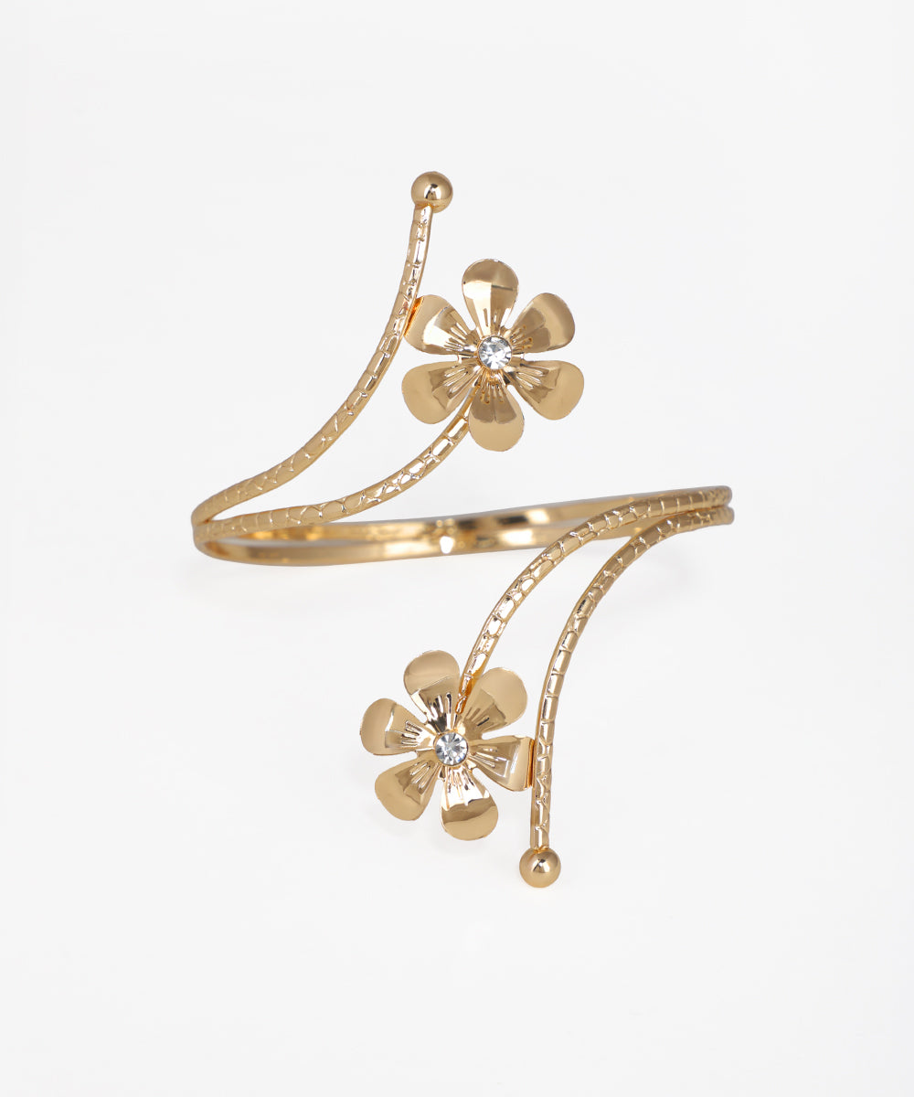 Gold bracelet with floral designs on a white background