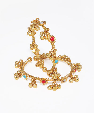 Gold bangles with colorful stones on a white background