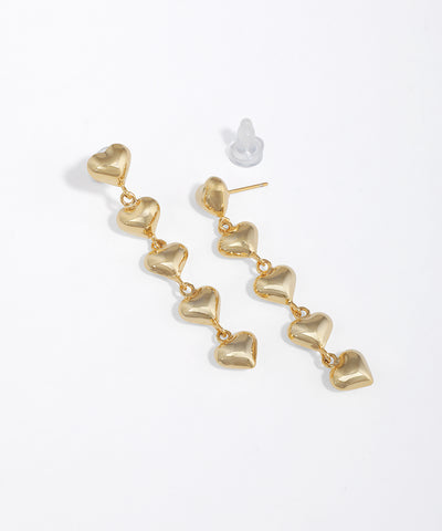 Gold-tone drop earrings with cascading puffed heart links and a shiny finish