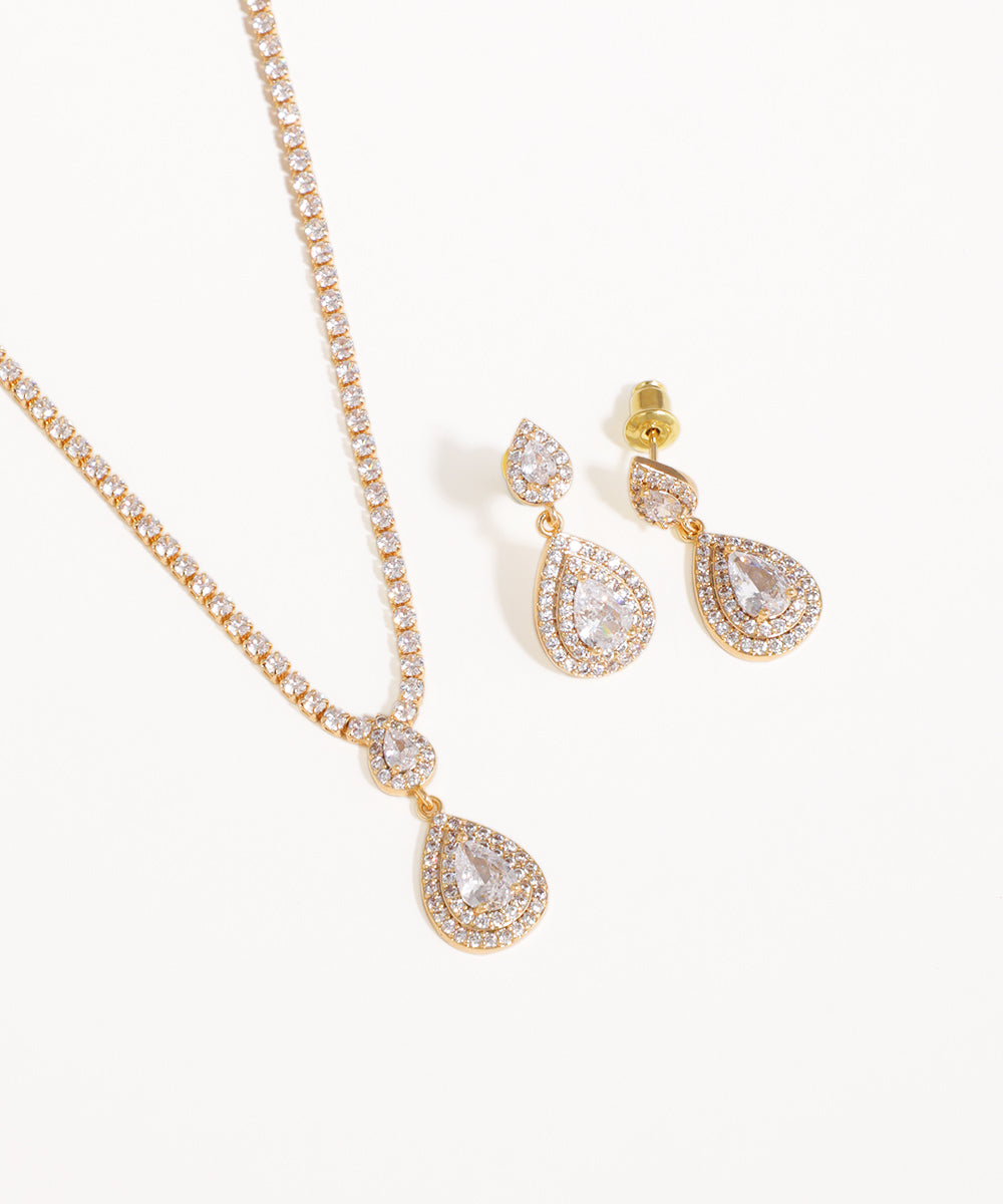 Gold necklace and earrings with teardrop designs on a white background