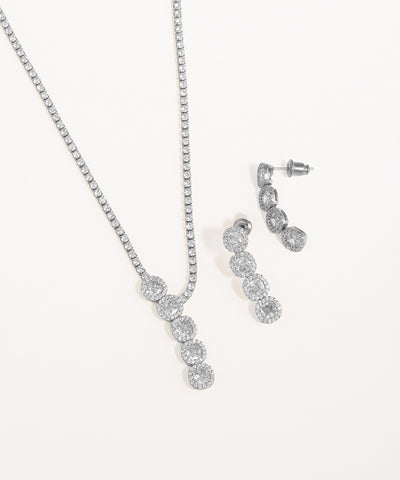 Silver necklace and earrings set on a white background