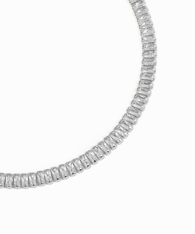 Rose gold necklace with clear gemstones on a white background
